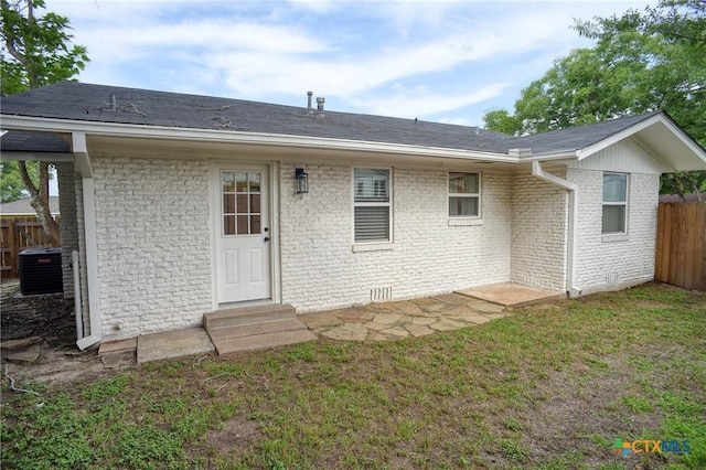 416 S Welhausen Ave, Shiner, TX 77984 - rear view of property with entry steps, central AC unit, and brick siding