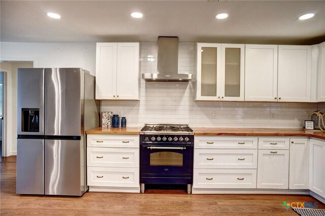 416 S Welhausen Ave, Shiner, TX 77984 - kitchen with stainless steel refrigerator with ice dispenser, wooden counters, wall chimney exhaust hood, gas range, and backsplash