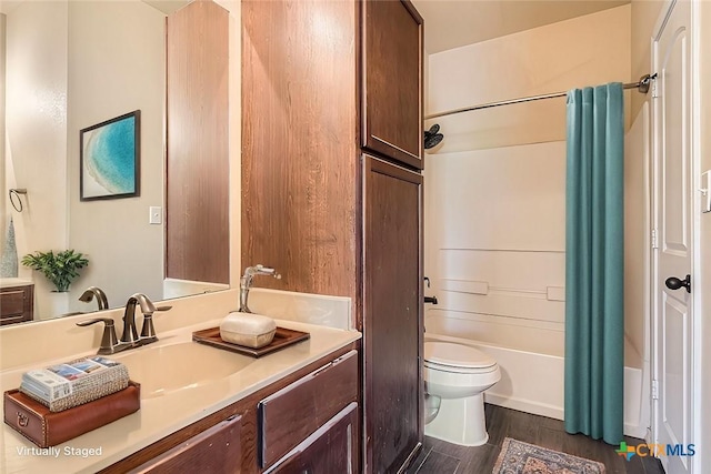 full bathroom with toilet, hardwood / wood-style flooring, shower / bath combo, and vanity