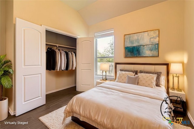 bedroom with a closet, lofted ceiling, and dark hardwood / wood-style floors