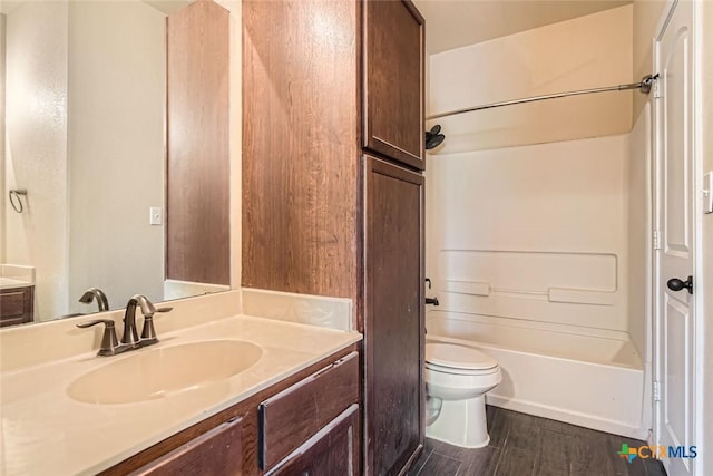 full bathroom with toilet, vanity, hardwood / wood-style flooring, and tub / shower combination