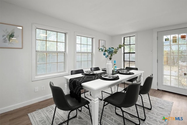 dining space with wood-type flooring