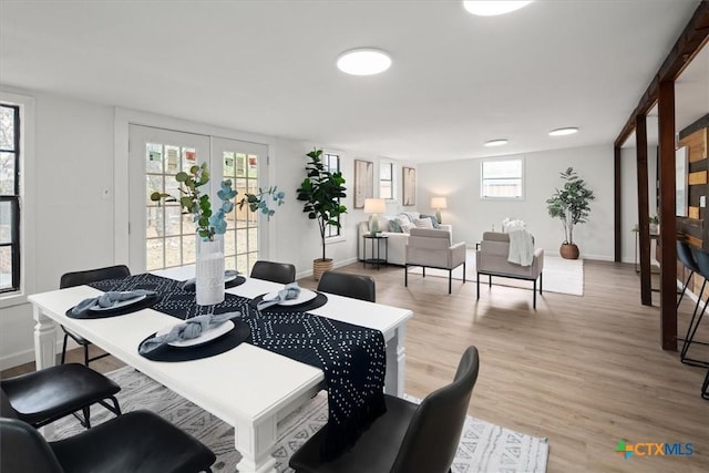 dining room featuring french doors and light hardwood / wood-style floors