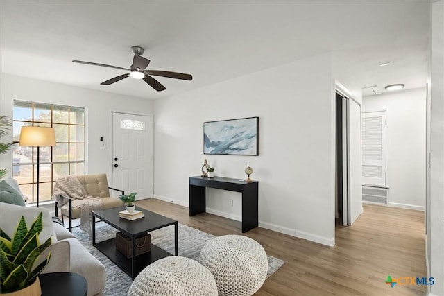 living room with ceiling fan and light hardwood / wood-style flooring