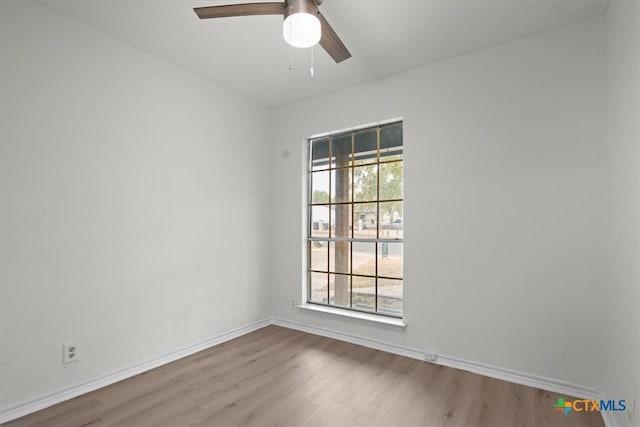 unfurnished room with ceiling fan, a wealth of natural light, and light wood-type flooring