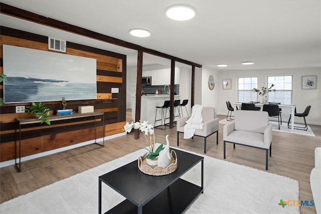 living room featuring wood walls and light hardwood / wood-style flooring