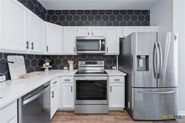 2215 Bellmont, Temple, TX 76504 - kitchen featuring appliances with stainless steel finishes, white cabinets, and light wood finished floors