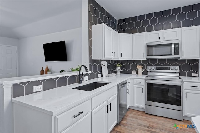 2215 Bellmont, Temple, TX 76504 - kitchen with stainless steel appliances, a sink, a peninsula, and white cabinets