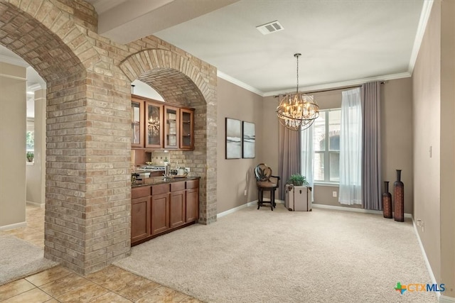 2303 Erica Kaitlin Ln, Cedar Park, TX 78613 - bar area with baseboards, a chandelier, crown molding, light colored carpet, and hanging light fixtures