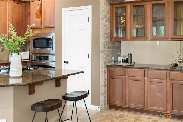 2303 Erica Kaitlin Ln, Cedar Park, TX 78613 - kitchen featuring appliances with stainless steel finishes, a breakfast bar, and brown cabinetry