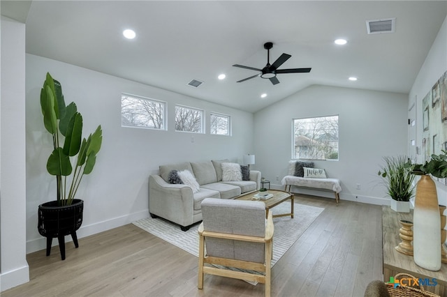 living room with ceiling fan, lofted ceiling, and light wood-type flooring