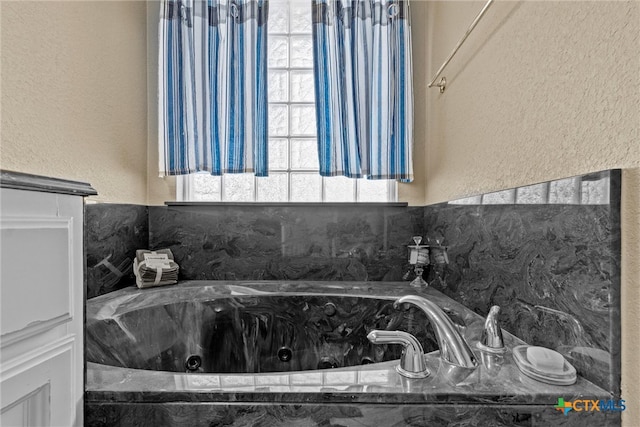 bathroom featuring tiled tub