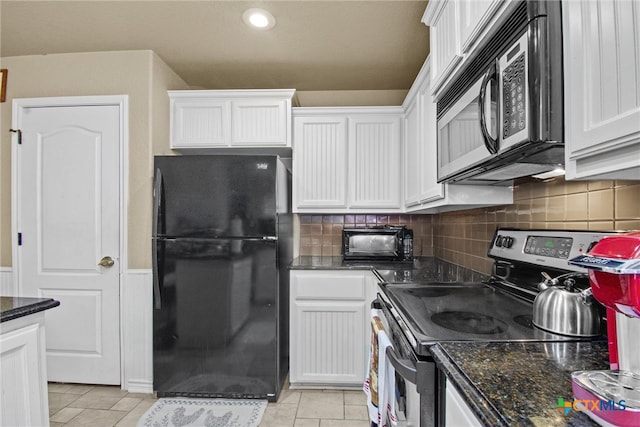 kitchen featuring decorative backsplash, light tile patterned floors, white cabinetry, appliances with stainless steel finishes, and dark stone countertops