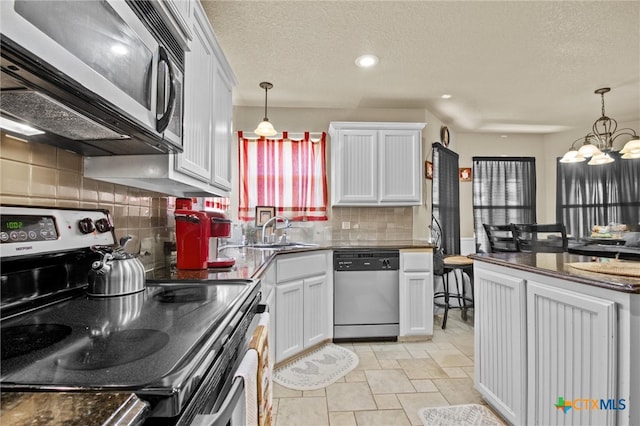 kitchen with stainless steel appliances, sink, tasteful backsplash, white cabinets, and pendant lighting