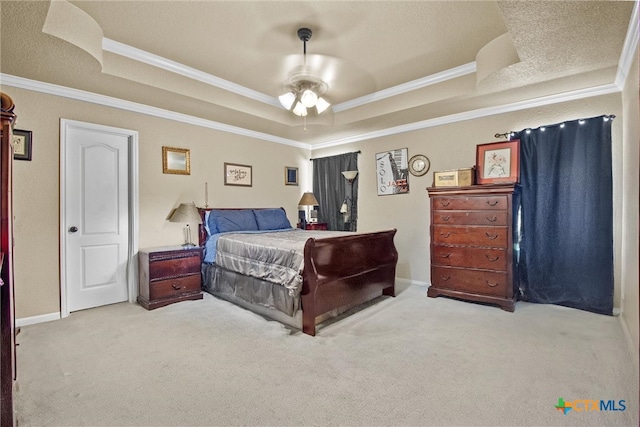 carpeted bedroom featuring a textured ceiling, ceiling fan, crown molding, and a tray ceiling