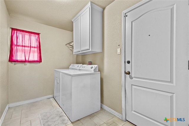 washroom with cabinets, separate washer and dryer, and a textured ceiling