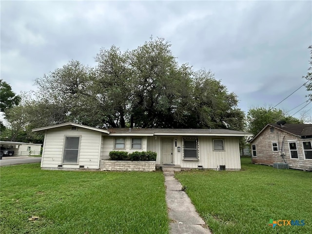 view of front of house with a front lawn and central AC