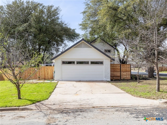 garage featuring driveway and fence