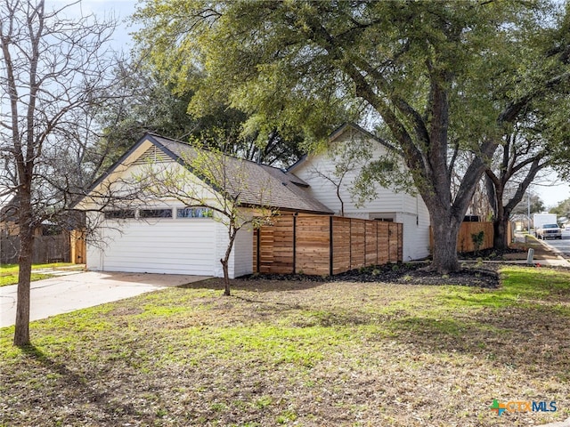 view of front of house with a garage, a shingled roof, and fence