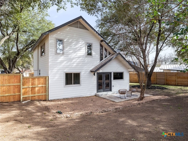 rear view of property featuring an outdoor fire pit, french doors, a patio area, and fence