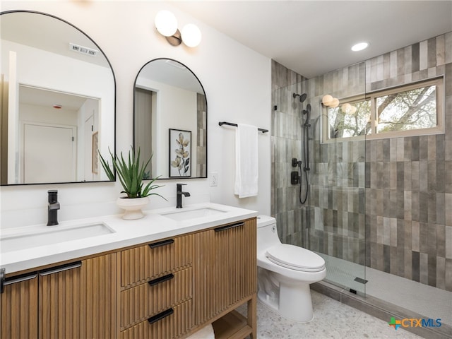 full bathroom with tiled shower, a sink, and toilet