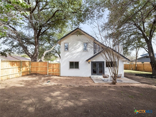 rear view of house with french doors, a patio area, and a fenced backyard