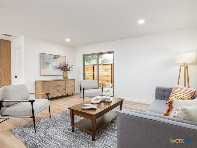 living room with light wood-style flooring, visible vents, and recessed lighting