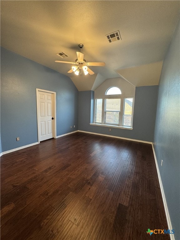 spare room featuring a ceiling fan, visible vents, vaulted ceiling, and wood finished floors