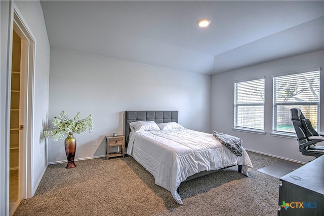 carpeted bedroom with vaulted ceiling and baseboards