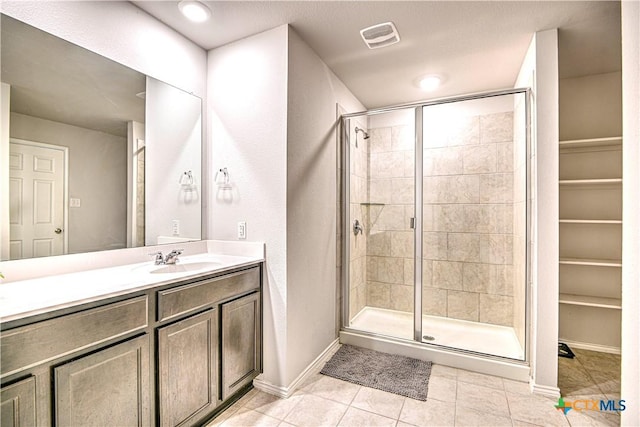 full bathroom featuring tile patterned floors, visible vents, vanity, and a shower stall