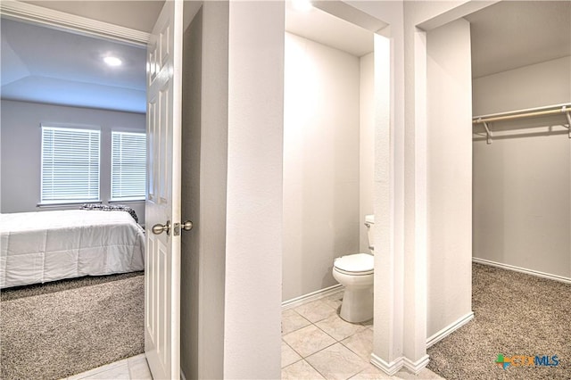 bathroom with toilet, ensuite bath, tile patterned flooring, baseboards, and a spacious closet