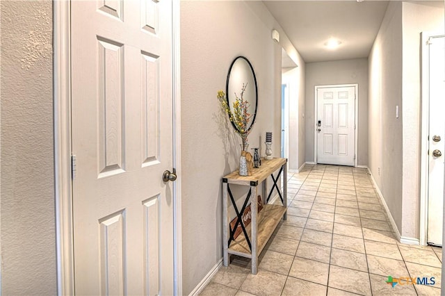 interior space with light tile patterned floors and baseboards