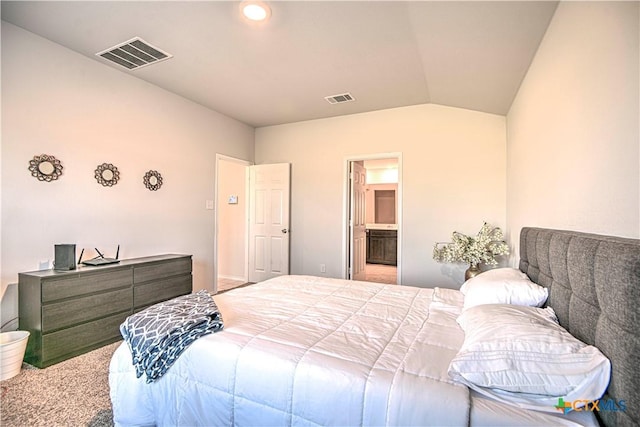 carpeted bedroom featuring lofted ceiling, visible vents, and ensuite bathroom