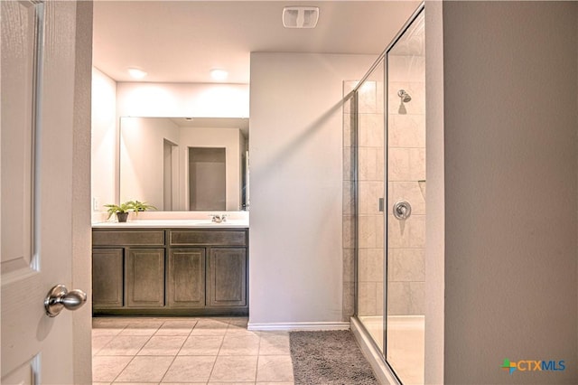 bathroom featuring visible vents, vanity, tile patterned flooring, and a tile shower