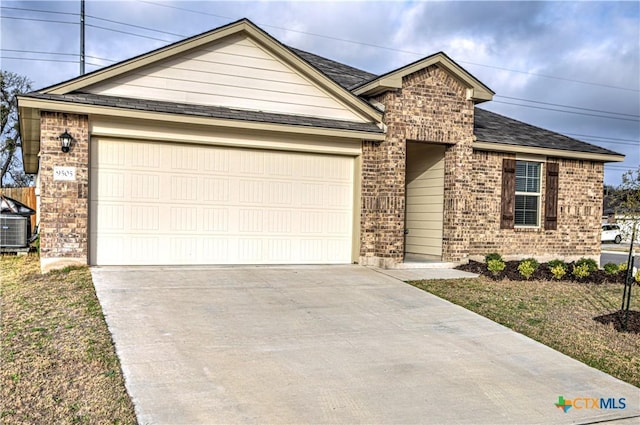 ranch-style home with driveway, a shingled roof, a garage, central air condition unit, and brick siding