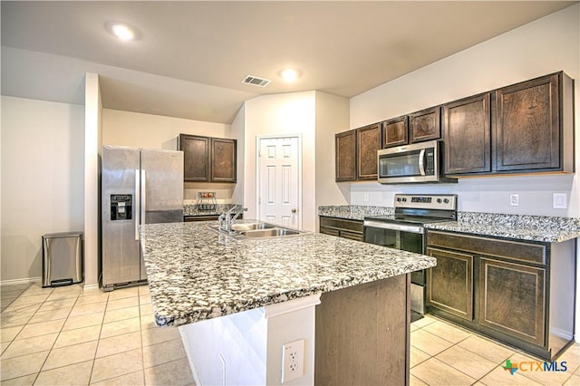 kitchen featuring visible vents, a sink, stainless steel appliances, dark brown cabinetry, and light tile patterned flooring