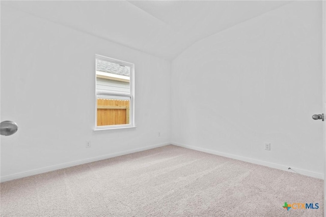 empty room with carpet flooring and lofted ceiling