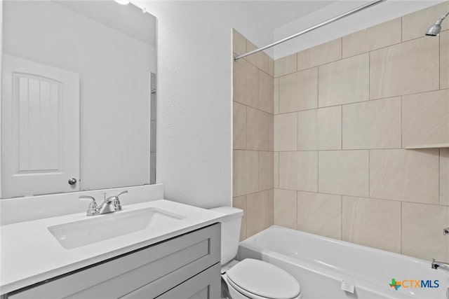 full bathroom with toilet, vanity, and tiled shower / bath