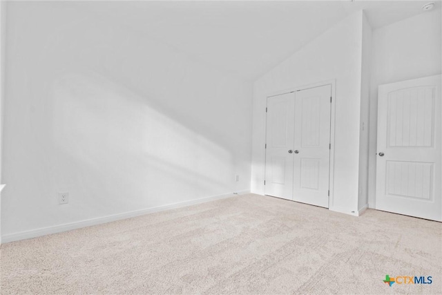 carpeted spare room featuring vaulted ceiling