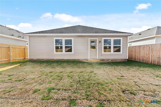 rear view of property with a yard