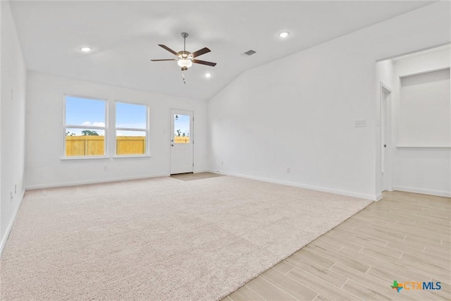 spare room featuring ceiling fan, light hardwood / wood-style floors, and vaulted ceiling