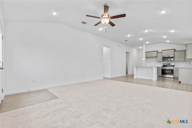 unfurnished living room featuring ceiling fan, light carpet, and vaulted ceiling