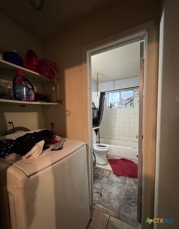 laundry area with washer / dryer and light tile patterned flooring