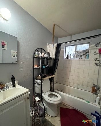 full bathroom with vanity, tiled shower / bath combo, and toilet