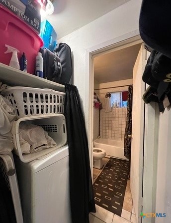 clothes washing area featuring light tile patterned flooring