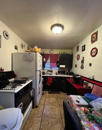 kitchen featuring light tile patterned floors and white gas stove