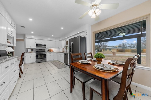 tiled dining space featuring ceiling fan