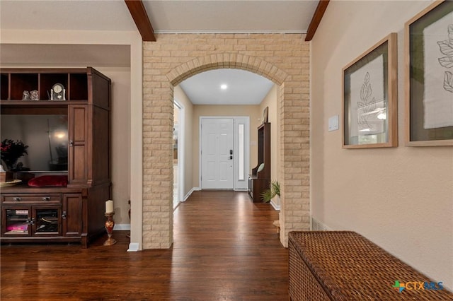 hallway featuring beamed ceiling, brick wall, and dark hardwood / wood-style flooring