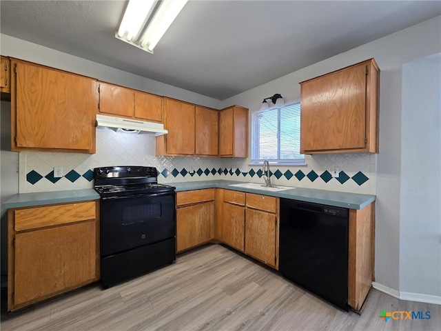 kitchen with backsplash, sink, black appliances, and light hardwood / wood-style flooring