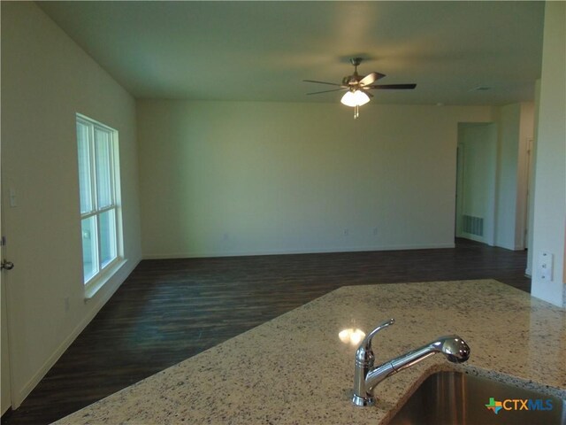 3204 Salt Fork Dr, Killeen, TX 76549 - kitchen with dark wood-type flooring, a sink, baseboards, a ceiling fan, and light stone countertops